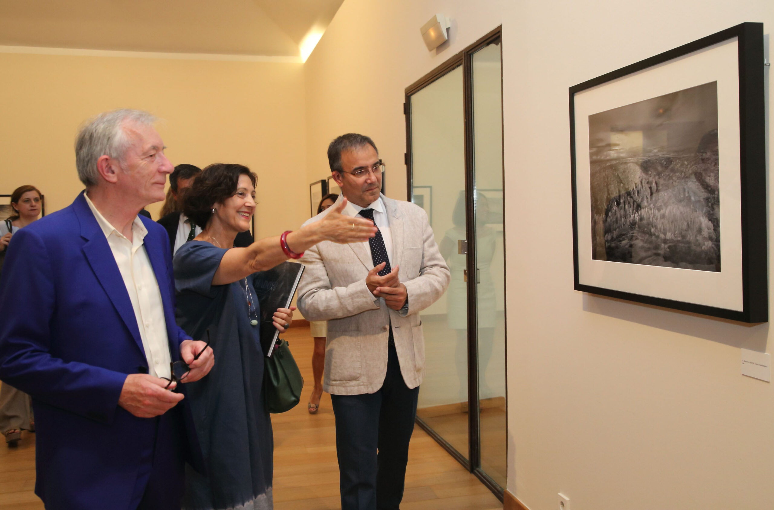 Toledo, 24-06-2016.- El viceconsejero de Cultura, Jesús Carrascosa, durante la apertura de la exposición ?Paisajes? de John Davies, dentro del proyecto ?Visiones de La Mancha?, una muestra enmarcada en los actos del IV Centenario de la muerte de Cervantes y del Festival PHotoEspaña 2016, en las salas del Museo de Santa Fe, junto a la comisaria de la exposición Oliva María Rubio y el autor de las fotografías, John Davies (i). (Foto: Álvaro Ruiz // JCCM)